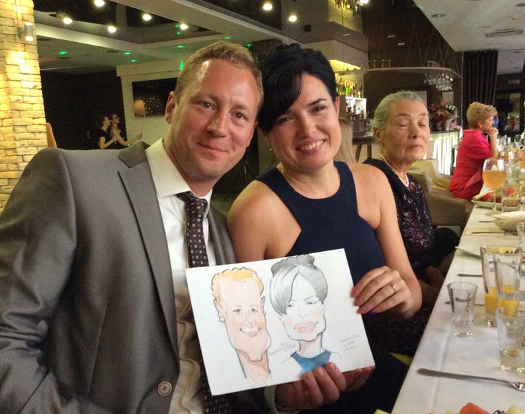 шаржист на корпоратив муж и жена держат шарж на корпоративе в Прайме свадьба
