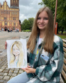 Наталья показывает шарж на острове Канта, шаржист Михаил Шабалин