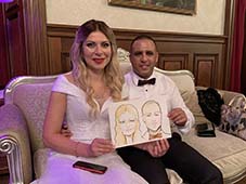 Алена и Арон держат свой свадебный шарж шаржист Михаил Шабалин Мишель